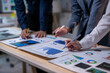 © Wasana - A group of people are working on a table with graphs and charts