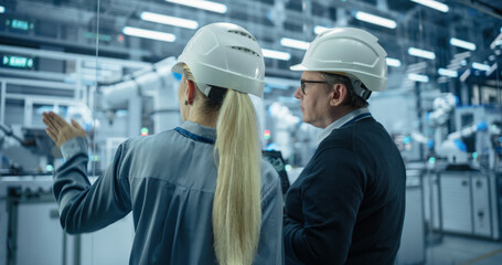 Leinwandbilder - Male Engineer and Female Project Manager Standing Next to an Assembly Line, Talking, Using Computer and Monitoring Production at a Modern Automated Electronics Manufacture with AI Robotic Arms
