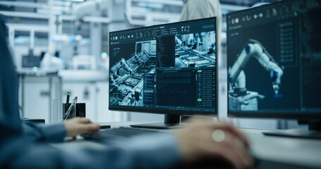 Fototapete - Portrait of a South Asian Engineer in a Hard Hat Working in an Industrial Facility. Indian Industrial Manager Using Laptop Computer to Monitor Robotic Arms in a Futuristic Electronics Factory