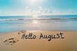 © Janja - Hello august written on beach sand at sunset welcoming summer month