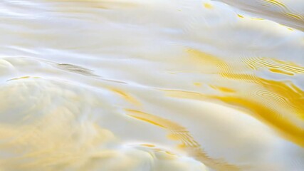 Wall Mural - An abstract view of a flowing blend of creamy white and rich golden hues. This artful image invites contemplation of textures, colors, and a unique perspective, suggesting fluid movement.