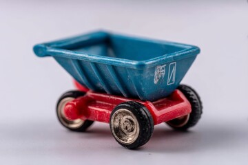 Poster - Miniature blue and red toy dump truck on a white background viewed from a slight angle