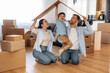 © standret - Positive facial expressions, paper from box. Family of husband, wife and son are moving into new house