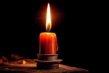 Poster - Candle flame illuminating darkness with warm glow on a rustic surface creating a serene atmosphere
