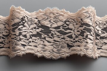 Aufkleber - Elegant lace ribbon displayed against a gray background showcasing intricate floral patterns and soft textures