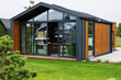 © AS Photo Family - Modern tiny house with glass facade and wooden exterior in a green environment
