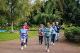 Group of active senior people doing running sport workout at city park - Healthy elderly lifestyle concept	
 - Soft focus on african woman