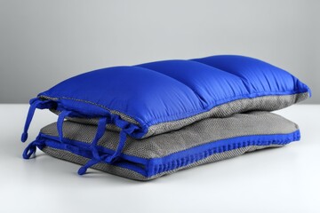 Poster - Cozy and colorful cushions stacked on a table ready for relaxation and comfort in a modern living space