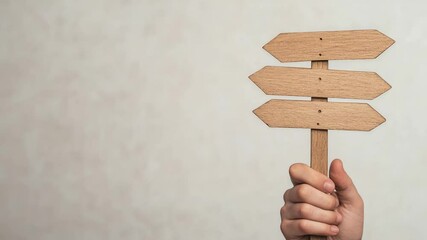 Poster - Multiple views of a hand holding a wooden directional sign with blank arrows against a white background, creating a sense of choice and decision making