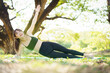 © DG PhotoStock - Asian woman training core muscles outdoors with plank and side plank poses under a tree in the park.