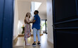 © wavebreak3 - Young couple laughing and embracing in modern home entrance hallway