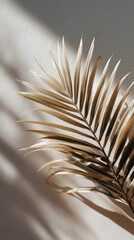 Poster - A striking palm leaf rests gently against a minimal beige background, capturing shadows and highlights that enhance its natural beauty