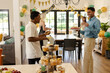 © wavebreak3 - Celebrating birthday, diverse friends sharing cake and chatting in decorated room