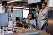 © WavebreakMediaMicro - African American woman reading card with flowers, colleagues applauding in office