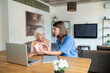 © zinkevych - Nurse taking care of disabled senior elderly woman using laptop computer together