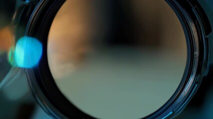 Wall Mural - A close-up view of a camera lens with a blurred background and colorful reflections.
