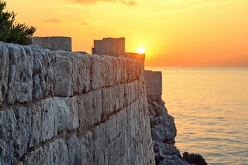 Poster - Sunset over the rocky seaside with ancient stone walls along the coastline, View of stone seaside during sunset