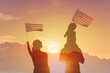 © kieferpix - Family waving American USA flag in sunset sky