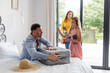 © WavebreakMediaMicro - Family packing suitcase at home, preparing for vacation with excitement