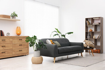 Aufkleber - Stylish living room with comfortable sofa and wooden shelving unit. Interior design