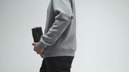 Poster - A person carrying a black suitcase in a gray sweatshirt, unknown context
