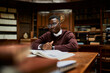 © Marko Geber - Portrait of a young african male student studying in a university library