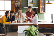© wavebreak3 - Teen friends celebrating good news in kitchen, smiling and holding paper