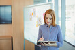 © WavebreakMediaMicro - Woman writing notes on tablet in modern conference room, with stylus and whiteboard, copy space