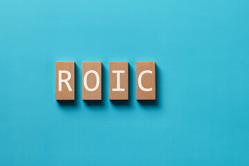Poster - there is wood block with the word roic. it is an abbreviation for return on invested capital as eye-