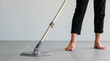 © sorapop - Woman mops the indoor floor, cleaning the front area of her home with a mop and rag. Housewife dedicated to maintaining cleanliness. Represents professional housekeeping and house maintenance concepts