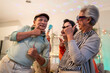 © Kawee - Group of Asian senior friend having evening party in living room at home.