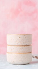Poster - Stack of Speckled White Ceramic Bowls on Pink Background
