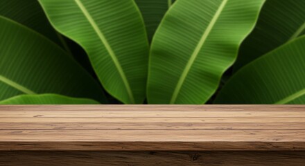 Poster - Wooden table with lush green banana leaves background, perfect for display.