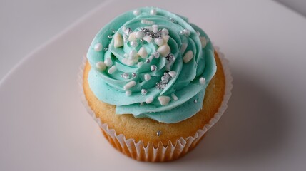 Poster - A close-up of a vanilla cupcake with teal frosting and silver sprinkles, highlighting beautiful dessert artistry against a white background