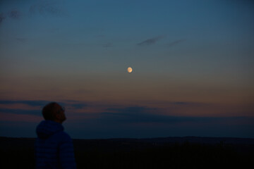 Wall Mural - silhouette of a man observing moon, milky way stars, planets and other celestial objects from a dark
