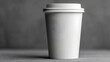 © Anuson - A clean white disposable coffee cup with a simple lid sits on a dark gray textured surface.
