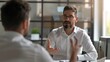 © SOEM - A manager giving constructive feedback to an employee during a one-on-one meeting.