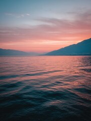 Wall Mural - Serene lake at sunset with mountains in background; dreamy pink and blue sky reflecting on water surface; landscape view; tranquil scene