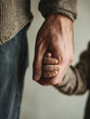 © Frenza - father holding a baby’s tiny hand, clean background in soft beige