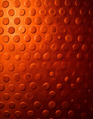 Leinwandbilder - Close up of a textured surface with raised dots in varying sizes, evenly spaced across a reddish brown background, creating a tactile and patterned effect.