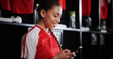 Happy, soccer and woman with phone in locker room for social media, contact and online communication. Athlete, football and person on smartphone for match, training and sports tournament schedule