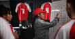 © peopleimages.com - Women, coach and writing with whiteboard for soccer game plan, match or player formation in locker room. Female people, coordinator or teaching sports team with presentation or meeting for strategy