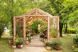 © stock_studio - Interior of a wooden greenhouse with furniture, plants and flowers in pots at backyard. Home gardening. Garden with glasshouse with chair with palette with paints, brushes and tools of artist stand