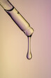 © ADDICTIVE STOCK - Close-up of a dropper with serum against colored background