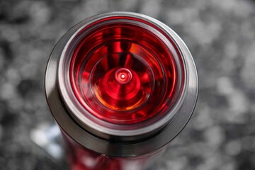 Leinwandbilder - Curved red and silver bottle with intricate design viewed from above, showcasing vibrant colors in modern settings
