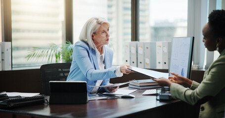 Fototapete - Women, documents and discussion with finance at office, review and feedback with charts by computer. Mature mentor, accounting and business people with paperwork, inspection and planning at agency
