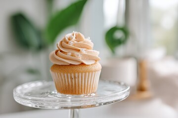 Poster - Delicious vanilla cupcake topped with creamy frosting displayed on a glass stand in a bright cafe setting