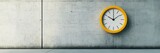 A simple, bright yellow clock on a neutral gray concrete wall