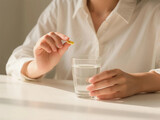 Dietary supplements,  girls holding pills and capsules, taking or consuming vitamin C and D to treat skin, hair, and nail strength at home, using purified water glass cups for health care.