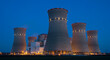 © tadek - Illuminated nuclear power plant at night with prominent cooling towers view